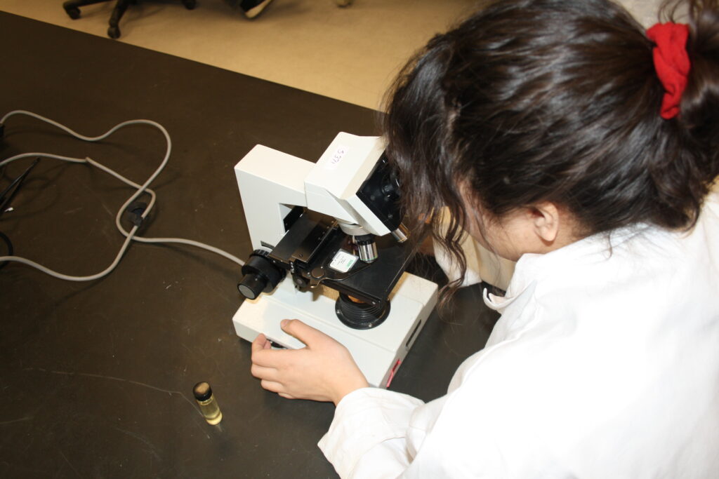 Indigenous student in a biology lab using a microscope