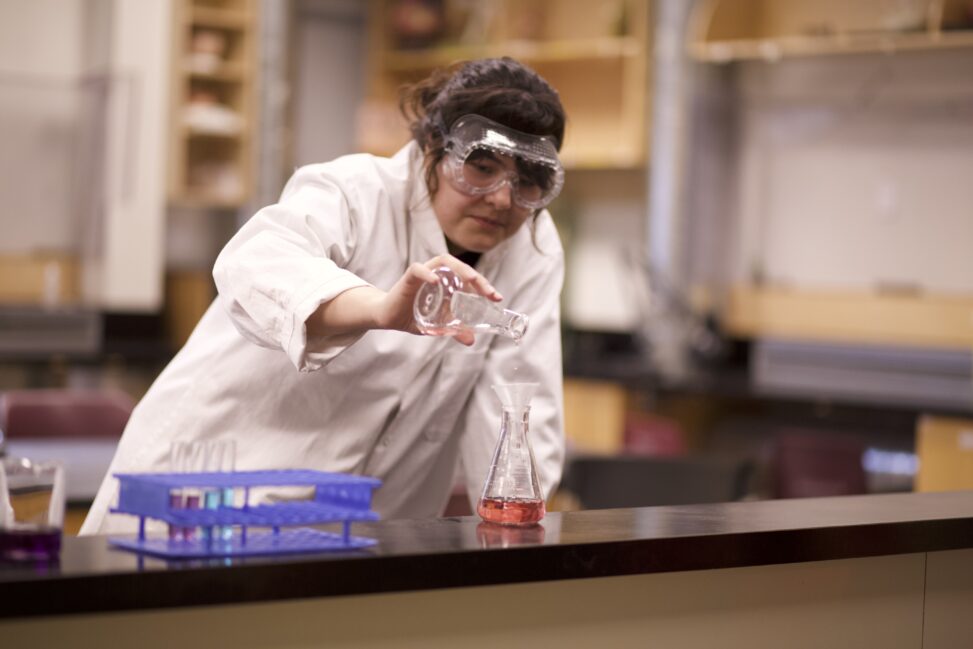 Indigenous student in a biology lab conducting an experiment.