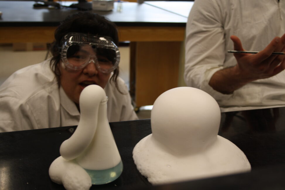 Indigenous students in a biology lab watching an experiment.